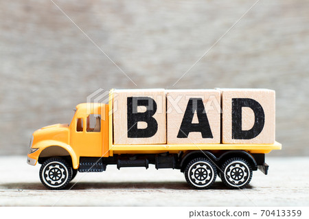 Truck hold letter block in word bad on wood background Truck hold letter block in word bad on wood background 70413359
