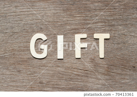 Alphabet letter in word gift on wood background Alphabet letter in word gift on wood background 70413361