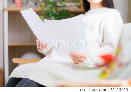 Pregnant woman looking at documents Pregnant woman looking at documents 70413463