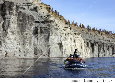 Landscape with a black dog on a boat with equipment on the river 70414097