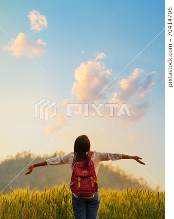 Young woman standing on a golden wheat field background. Young woman standing on a golden wheat field background. 70414708