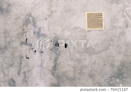 old grey concrete garage wall with spots of black paint with white ventilation grille 70415197