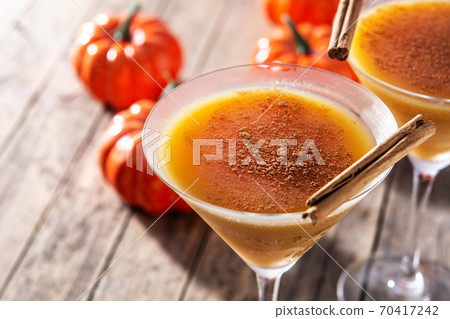 Pumpkin cocktail in glass on rustic wooden table Pumpkin cocktail in glass on rustic wooden table 70417242