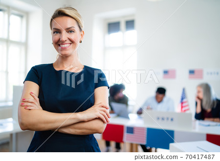 Portrait of confident woman voter in polling place, usa elections concept. Portrait of confident woman voter in polling place, usa elections concept. 70417487