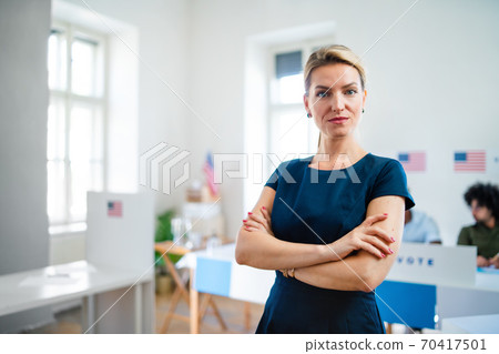 Portrait of confident woman voter in polling place, usa elections concept. 70417501