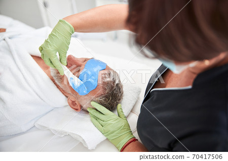 Professional spa therapist doing skincare procedures for a customer 70417506