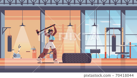 sportswoman hitting tire with hummer girl doing hard exercises working out fitness training healthy lifestyle 70418044