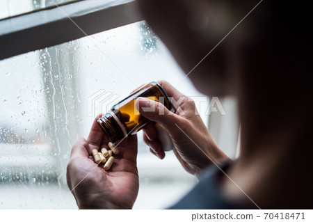 Depressed woman indoors at home, mental health and drugs addiction concept. 70418471