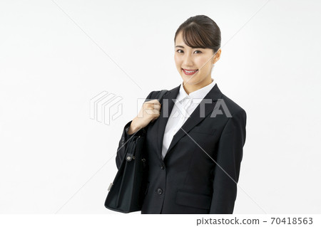 Young woman in a suit with a bag 70418563