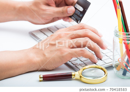Person entering number of credit card with white 70418583