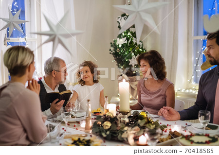 Small girl with parents and grandparents indoors celebrating Christmas. 70418585