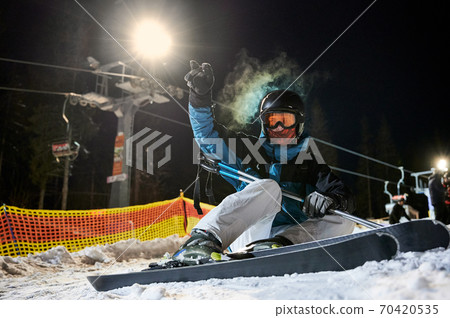 Young man skiing at ski resort at night. 70420535
