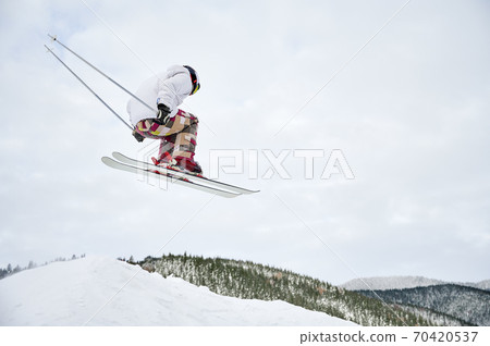 Winter kinds of sport. Skier doing tricks in the mountains in winter season Winter kinds of sport. Skier doing tricks in the mountains in winter season 70420537