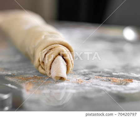 Rolled cinnamon dough on a baking sheet in the oven. Rolled cinnamon dough on a baking sheet in the oven. 70420797