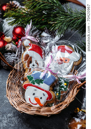 Festive gingerbread cookies in the form of Santa Claus, bears and a snowman in a beautiful festive basket on a decorative background 70420967