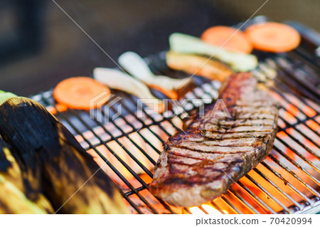 Grilling beef steaks over a barbecue over a barbecue [The real pleasure of the outdoors] 70420994
