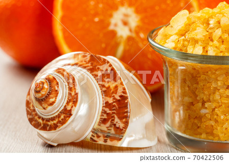 Cut orange, sea shall and glass bowl with yellow sea salt 70422506