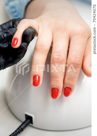 Young woman receives red nail polish 70424078