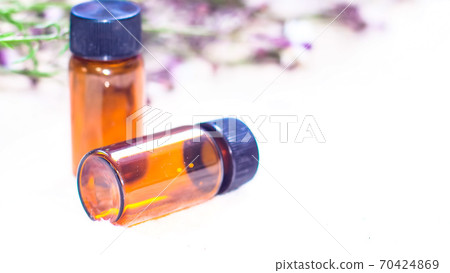 Bottle of essential oil. Herbal medicine or aromatherapy dropper bottle isolated on white background. Fresh rosemary flowers and essential oils on the table Bottle of essential oil. Herbal medicine or aromatherapy dropper bottle isolated on white background. Fresh rosemary flowers and essential oils on the table 70424869