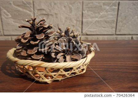 Pine cones and acorns in a basket Pine cones and acorns in a basket 70426364