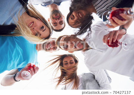 summer vacation, happy people - a group of teenagers looking down with a happy smile on his face. summer vacation, happy people - a group of teenagers looking down with a happy smile on his face. 70427137