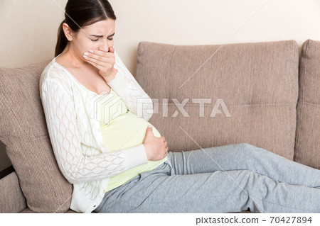 Pregnancy Morning Sickness. Pregnant Woman Having Nausea Feeling Bad in Sofa at the Home Pregnancy Morning Sickness. Pregnant Woman Having Nausea Feeling Bad in Sofa at the Home 70427894