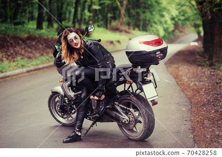 An attractive sexy girl on a sports motorbike posing outside An attractive sexy girl on a sports motorbike posing outside 70428258
