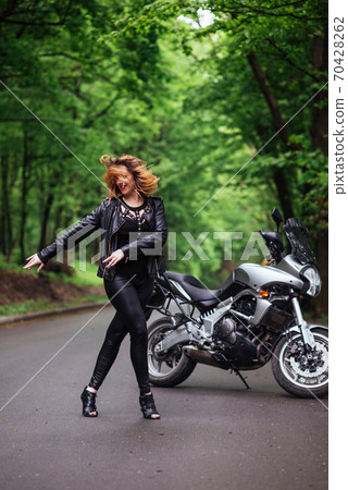 An attractive sexy girl on a sports motorbike posing outside An attractive sexy girl on a sports motorbike posing outside 70428262