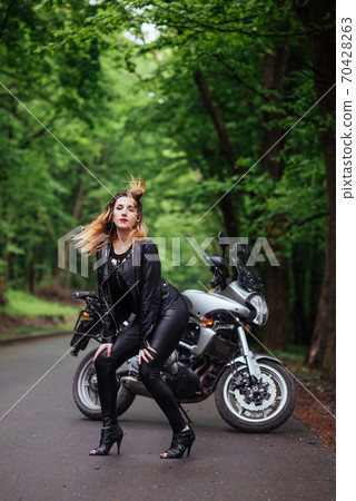 An attractive sexy girl on a sports motorbike posing outside An attractive sexy girl on a sports motorbike posing outside 70428263