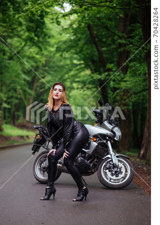 An attractive sexy girl on a sports motorbike posing outside An attractive sexy girl on a sports motorbike posing outside 70428264