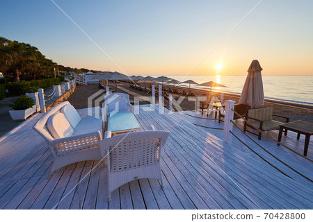 Scenic view of sandy beach on the beach with sun beds and umbrellas open against the sea and mountains. Hotel. Resort. Tekirova-Kemer Scenic view of sandy beach on the beach with sun beds and umbrellas open against the sea and mountains. Hotel. Resort. Tekirova-Kemer 70428800