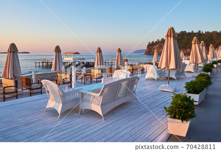 Scenic view of sandy beach on the beach with sun beds and umbrellas open against the sea and mountains. Hotel. Resort. Tekirova-Kemer Scenic view of sandy beach on the beach with sun beds and umbrellas open against the sea and mountains. Hotel. Resort. Tekirova-Kemer 70428811