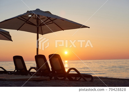 Scenic view of sandy beach on the beach with sun beds and umbrellas open against the sea and mountains. Hotel. Resort. Tekirova-Kemer Scenic view of sandy beach on the beach with sun beds and umbrellas open against the sea and mountains. Hotel. Resort. Tekirova-Kemer 70428828