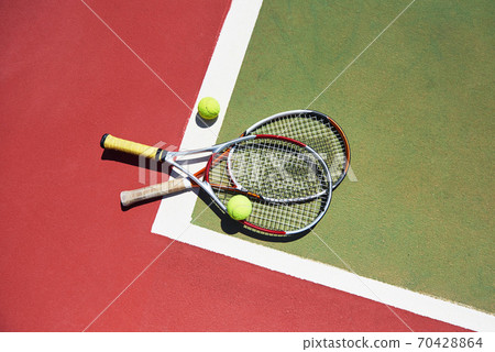A tennis racket and new tennis ball on a freshly painted tennis court 70428864