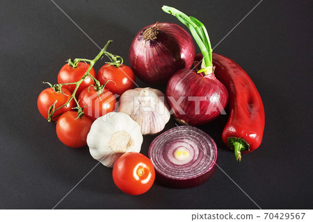 onion and garlic and hot peppers and tomatoes isolated on a black background. onion and garlic and hot peppers and tomatoes isolated on a black background. 70429567
