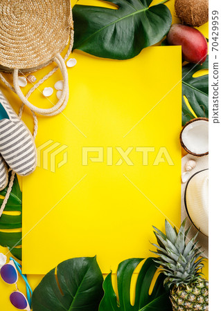 Straw hat, camera, bag, summer shoes, sunglasses, shells, tropical leaves and fruits over yellow background Straw hat, camera, bag, summer shoes, sunglasses, shells, tropical leaves and fruits over yellow background 70429959