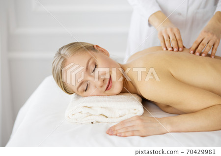 Beautiful caucasian woman enjoying back massage with closed eyes. Beauty and Spa salon concept 70429981