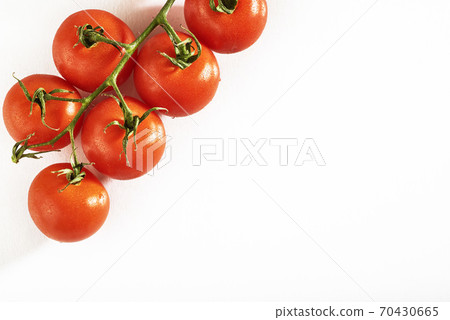 Branch of red organic tomatoes on a white background Branch of red organic tomatoes on a white background 70430665