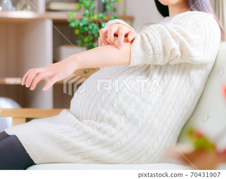 Pregnant woman scratching her arm 4: 3 Pregnant woman scratching her arm 4: 3 70431907