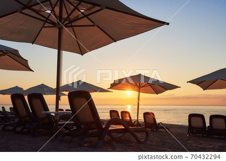 Scenic view of sandy beach on the beach with sun beds and umbrellas open against the sea and mountains. Amara Dolce Vita Luxury Hotel. Resort. Tekirova-Kemer Scenic view of sandy beach on the beach with sun beds and umbrellas open against the sea and mountains. Amara Dolce Vita Luxury Hotel. Resort. Tekirova-Kemer 70432294