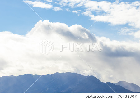 Mountain range in clear weather in contrasting rain clouds Mountain range in clear weather in contrasting rain clouds 70432307