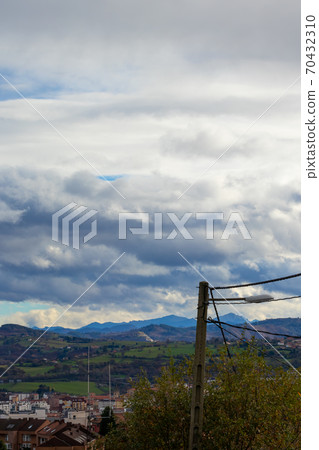 Mountain range in clear weather in contrasting rain clouds Mountain range in clear weather in contrasting rain clouds 70432310