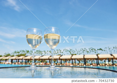 Glasses of champagne at a resort pool in a luxury hotel. Party by the pool. Pouring drink in a glass. Amara Dolce Vita Luxury Hotel. Resort. Tekirova-Kemer 70432730