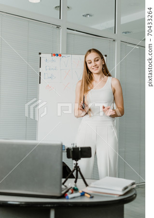 Side hustle, earn extra, money making, side job, side money, second job, hustling, hustle gig, gig economy concept. Young woman speaking in front of camera for vlog blog, recording video tutorial 70433264