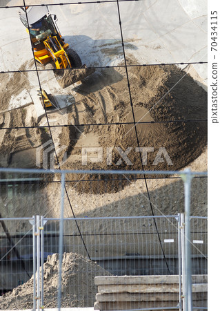 Construction site with an excavator and a heap of sand Construction site with an excavator and a heap of sand 70434115
