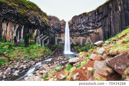 Great view of Svartifoss waterfall. Dramatic and picturesque scene. Popular tourist attraction. Iceland 70434266
