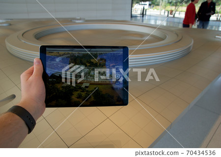 CUPERTINO, CALIFORNIA, UNITED STATES - NOV 26th, 2018: People at the Apple Park Visitor Center in Silicon Valley explore the new Apple Offices using a scaled-down replica of the campus and a virtual 70434536