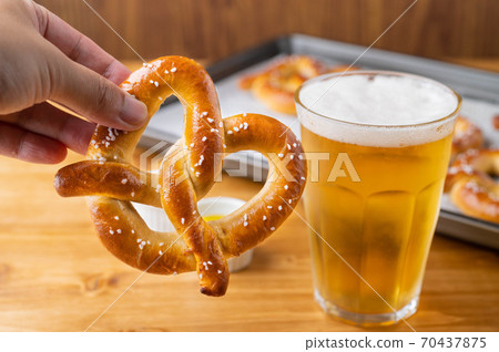 baked pretzel on cooking pan with beer baked pretzel on cooking pan with beer 70437875