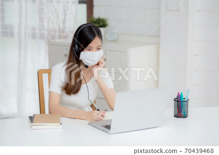 Young asian woman wearing headphone study online with e-learning on desk. Young asian woman wearing headphone study online with e-learning on desk. 70439468