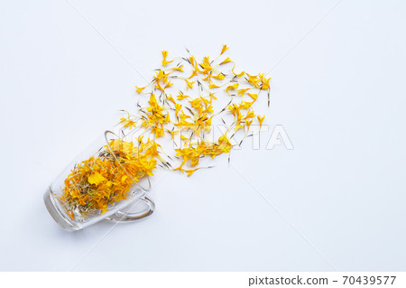 A glass cup with marigold flower petals on white background Flower herbal tea concept. A glass cup with marigold flower petals on white background Flower herbal tea concept. 70439577